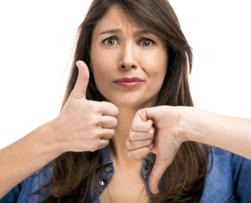 Beautiful woman confused making thumbs up and down